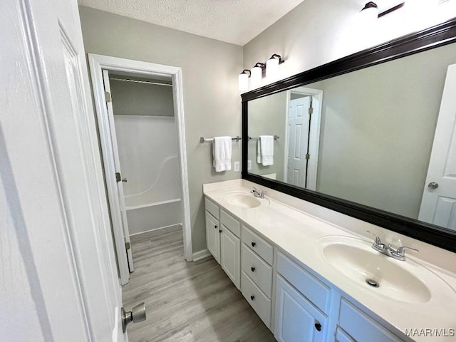 2495 Chancellor Ridge Rd, Prattville, AL 36066 - full bath with double vanity, a textured ceiling, wood finished floors, and a tub to relax in