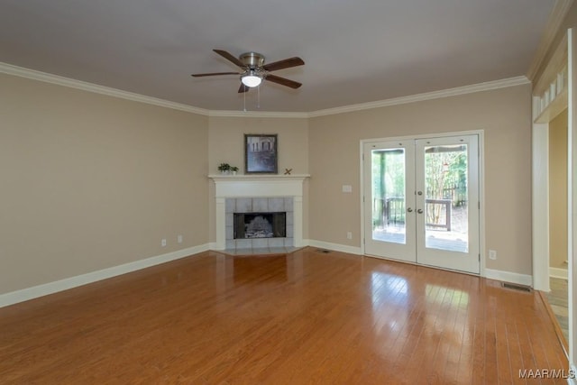 240 Winding Wood Dr, Wetumpka, AL 36093 - unfurnished living room with french doors, ceiling fan, wood finished floors, ornamental molding, and a tile fireplace