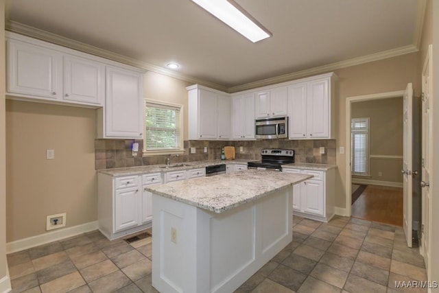 240 Winding Wood Dr, Wetumpka, AL 36093 - kitchen featuring stainless steel microwave, electric range, crown molding, white cabinets, and backsplash