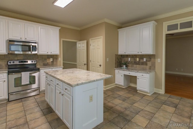 240 Winding Wood Dr, Wetumpka, AL 36093 - kitchen with appliances with stainless steel finishes, tasteful backsplash, white cabinetry, crown molding, and a kitchen island