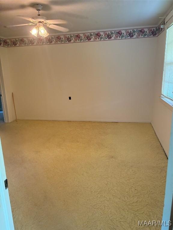 407 Powers Ave, Tallassee, AL 36078 - spare room featuring ceiling fan, carpet floors, and healthy amount of natural light