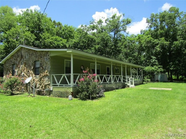1716 Old Federal Rd, Shorter, AL 36075 - back of house with covered porch, a lawn, stone siding, and a shed