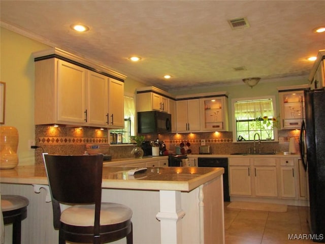 1716 Old Federal Rd, Shorter, AL 36075 - kitchen featuring black appliances, a peninsula, ornamental molding, tasteful backsplash, and a kitchen bar