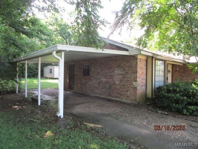 1333 Pembrook Ct, Montgomery, AL 36109 - view of parking with a carport, driveway, and a storage unit