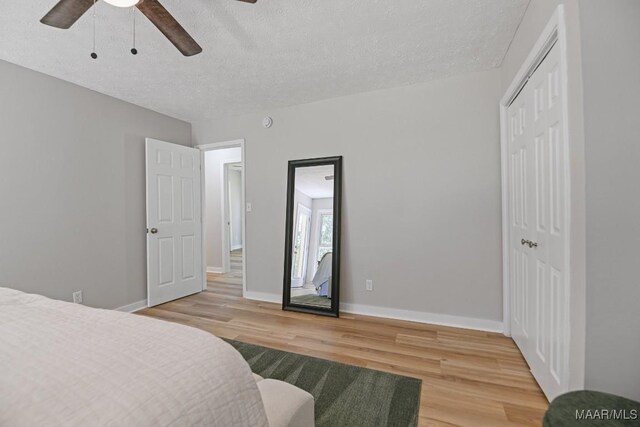 5010 Redland Rd, Wetumpka, AL 36093 - bedroom featuring light wood-style flooring, a textured ceiling, a closet, and ceiling fan