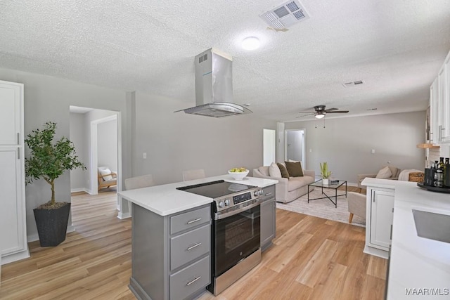 5010 Redland Rd, Wetumpka, AL 36093 - kitchen featuring stainless steel electric range, island exhaust hood, gray cabinetry, light wood-style flooring, and ceiling fan