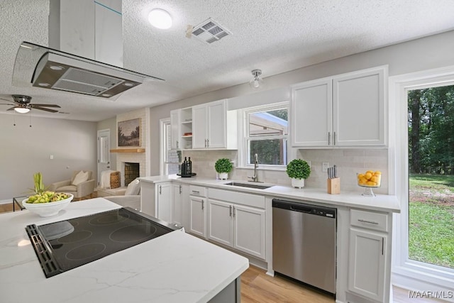 5010 Redland Rd, Wetumpka, AL 36093 - kitchen with stainless steel dishwasher, a textured ceiling, backsplash, a large fireplace, and light wood-type flooring