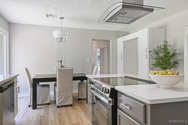 5010 Redland Rd, Wetumpka, AL 36093 - kitchen with appliances with stainless steel finishes, a textured ceiling, light wood finished floors, light countertops, and decorative light fixtures