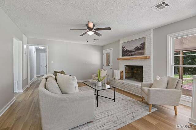 5010 Redland Rd, Wetumpka, AL 36093 - living area with ceiling fan, wood finished floors, a fireplace, and a textured ceiling