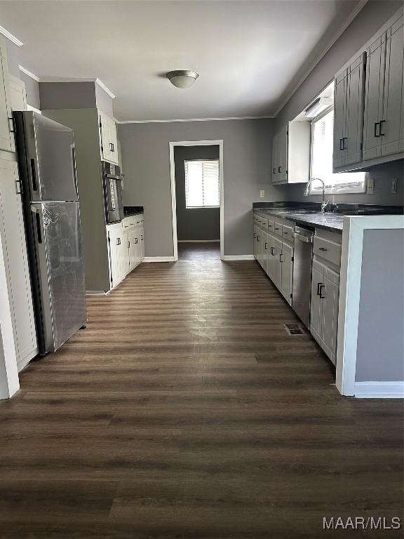 705 Mastin Lake Rd NW, Huntsville, AL 35811 - kitchen with appliances with stainless steel finishes, crown molding, dark wood-style flooring, dark countertops, and gray cabinets