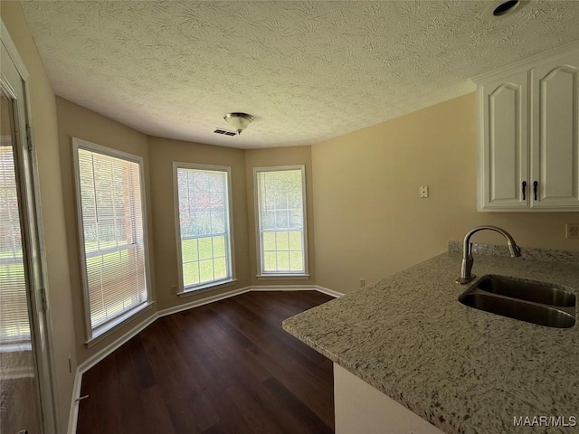 7415 Brampton Ln, Montgomery, AL 36117 - kitchen with light stone countertops, dark wood-type flooring, white cabinets, a textured ceiling, and a peninsula