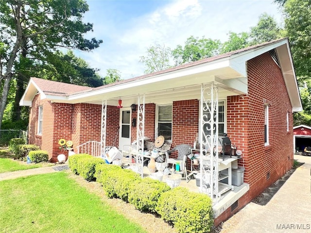 view of front of home with crawl space, brick siding, and a porch