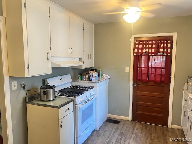 kitchen featuring under cabinet range hood, gas range gas stove, light wood-style flooring, white cabinetry, and a ceiling fan