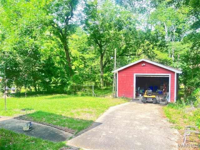 view of green lawn featuring an outbuilding, a garage, and driveway