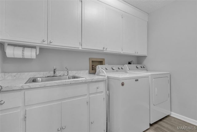 113 Duck Cv, Elmore, AL 36025 - laundry area featuring cabinet space, separate washer and dryer, light wood-style floors, and a textured ceiling