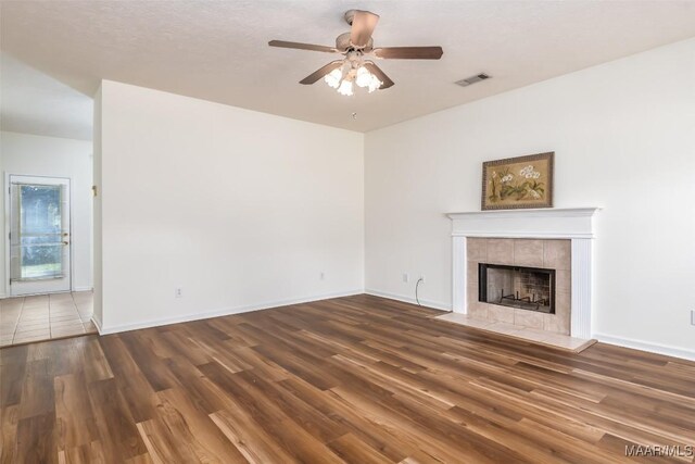 422 River Oaks Dr, Wetumpka, AL 36092 - unfurnished living room with wood finished floors, ceiling fan, and a tiled fireplace