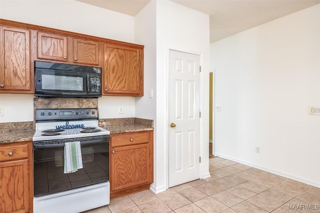 422 River Oaks Dr, Wetumpka, AL 36092 - kitchen featuring white electric stove, black microwave, and brown cabinetry