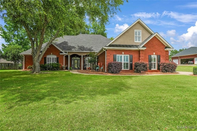 145 Mountain Meadows Ln, Wetumpka, AL 36093 - traditional-style house featuring brick siding, a front lawn, a standing seam roof, and stucco siding