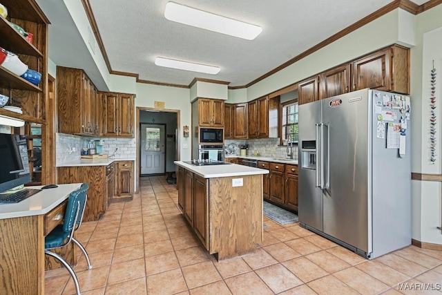 4015 Snowdoun Chambers Rd, Montgomery, AL 36116 - kitchen with stainless steel appliances, a kitchen island, backsplash, light countertops, and crown molding