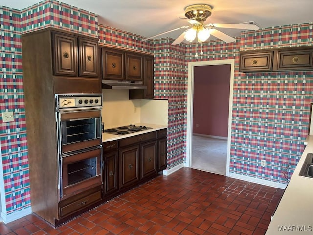 216 Cone Dr, Selma, AL 36701 - kitchen with double wall oven, black electric stovetop, a ceiling fan, wallpapered walls, and light countertops