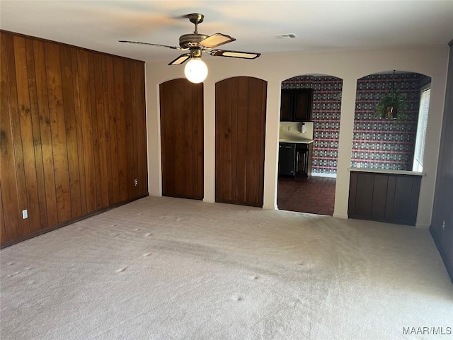 216 Cone Dr, Selma, AL 36701 - carpeted spare room with arched walkways, a ceiling fan, and wood walls