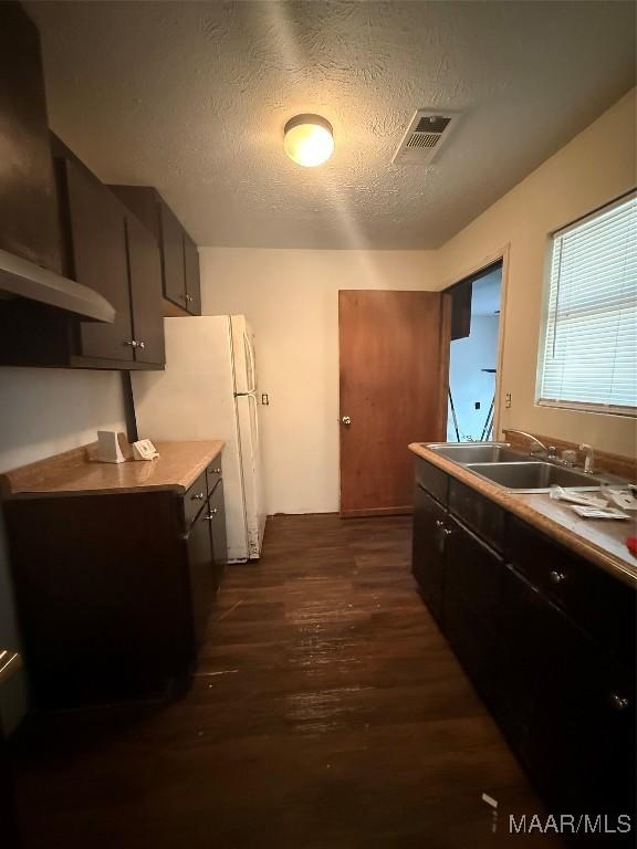 235 Wild Plum Trl, Wetumpka, AL 36093 - kitchen with dark wood-type flooring, a textured ceiling, light countertops, and freestanding refrigerator