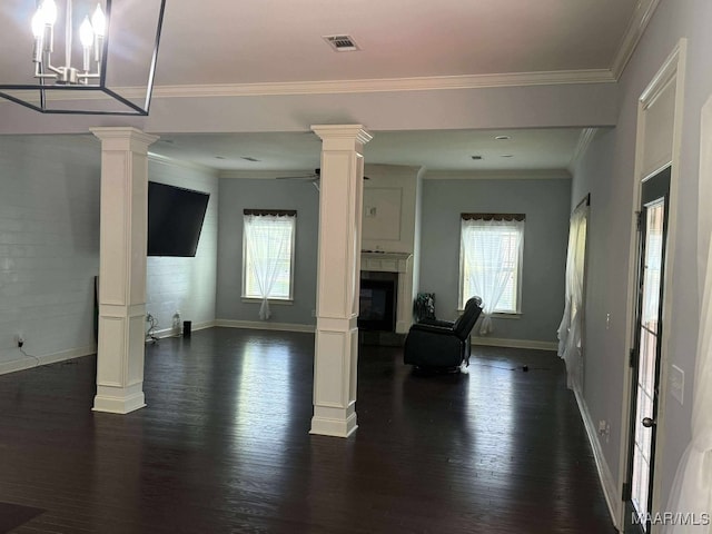 312 Sherwood Trl, Wetumpka, AL 36093 - living area featuring ornate columns, healthy amount of natural light, dark wood-style flooring, a fireplace with raised hearth, and crown molding