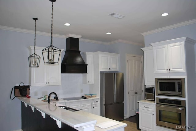 312 Sherwood Trl, Wetumpka, AL 36093 - kitchen with stainless steel appliances, premium range hood, a peninsula, a kitchen bar, and white cabinetry
