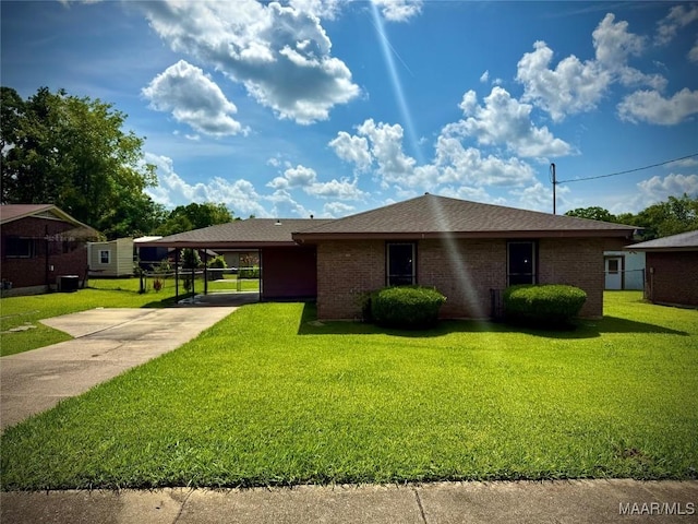 5204 Patricia Ln, Montgomery, AL 36108 - view of front of house featuring a front yard, concrete driveway, an attached carport, and brick siding