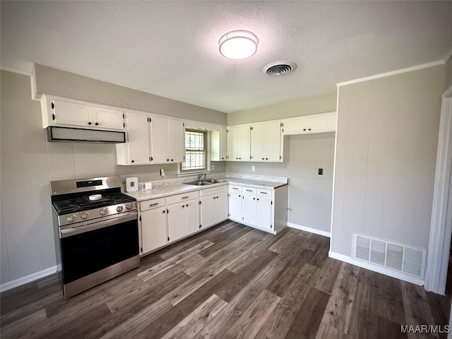 5204 Patricia Ln, Montgomery, AL 36108 - kitchen featuring stainless steel gas range oven, range hood, a textured ceiling, dark wood-style floors, and light countertops
