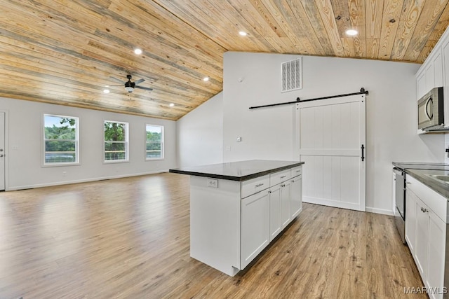 1415 Gold Mine Branch Rd, Marbury, AL 36051 - kitchen with wooden ceiling, a barn door, dark countertops, light wood-type flooring, and open floor plan