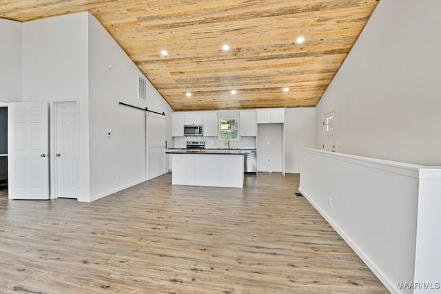 1415 Gold Mine Branch Rd, Marbury, AL 36051 - kitchen with stainless steel appliances, wood ceiling, a barn door, dark countertops, and white cabinetry
