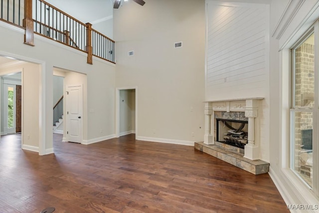79 Birchwood Ln, Wetumpka, AL 36093 - unfurnished living room with wood finished floors, ceiling fan, stairs, a fireplace, and a towering ceiling