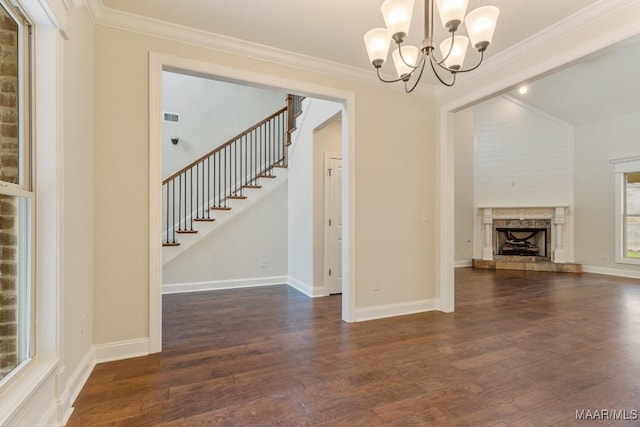 79 Birchwood Ln, Wetumpka, AL 36093 - unfurnished living room with a chandelier, dark wood-type flooring, stairs, crown molding, and a fireplace with raised hearth
