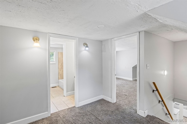 1310 Woodward Ave, Montgomery, AL 36106 - hallway with a textured ceiling, carpet flooring, and tile patterned floors