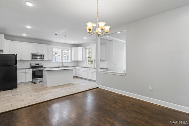 1310 Woodward Ave, Montgomery, AL 36106 - kitchen featuring appliances with stainless steel finishes, recessed lighting, a chandelier, white cabinets, and light wood finished floors