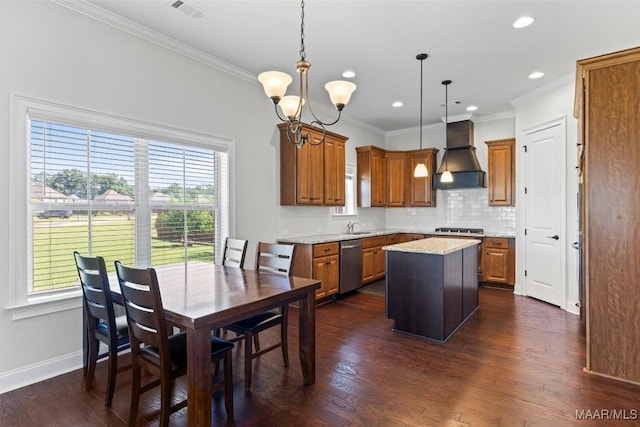 8465 Melbourne Cir, Montgomery, AL 36117 - kitchen featuring premium range hood, appliances with stainless steel finishes, a kitchen island, brown cabinetry, and healthy amount of natural light