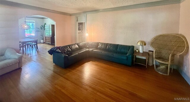 3319 Lexington Rd, Montgomery, AL 36106 - living area featuring arched walkways, wood finished floors, crown molding, a textured ceiling, and a textured wall