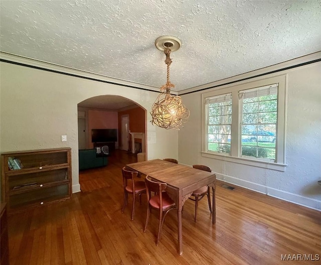 3319 Lexington Rd, Montgomery, AL 36106 - dining room featuring a textured ceiling, arched walkways, and wood finished floors