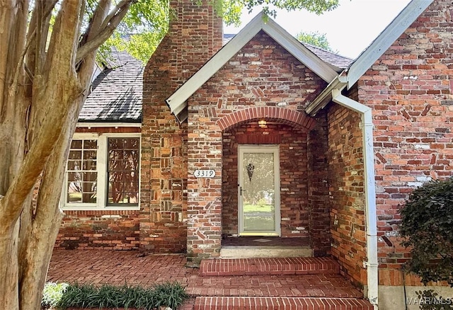 3319 Lexington Rd, Montgomery, AL 36106 - view of exterior entry featuring a chimney, brick siding, and roof with shingles