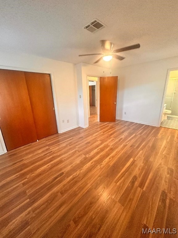 508 Columbus Dr, Selma, AL 36701 - unfurnished bedroom with a textured ceiling, wood finished floors, ensuite bathroom, and ceiling fan