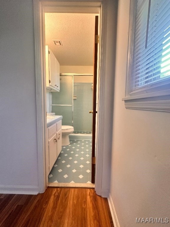 508 Columbus Dr, Selma, AL 36701 - bathroom with an enclosed shower, wood finished floors, vanity, and a textured ceiling
