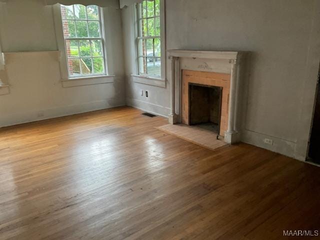 158 S Madison Ter, Montgomery, AL 36107 - unfurnished living room featuring wood finished floors and a fireplace with flush hearth