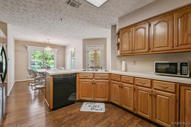 165 Ten Cedars Dr, Titus, AL 36080 - kitchen featuring black dishwasher, stainless steel microwave, a peninsula, light countertops, and dark wood-style floors