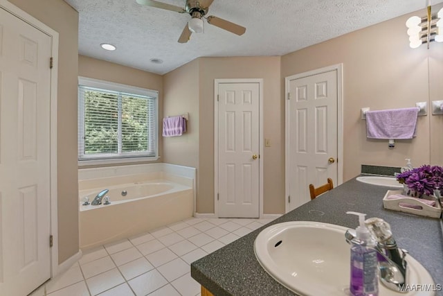 165 Ten Cedars Dr, Titus, AL 36080 - full bathroom featuring tile patterned flooring, double vanity, a ceiling fan, a bath, and a textured ceiling