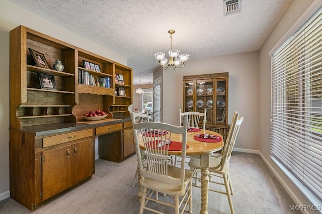 165 Ten Cedars Dr, Titus, AL 36080 - dining space featuring a chandelier, light colored carpet, and a textured ceiling