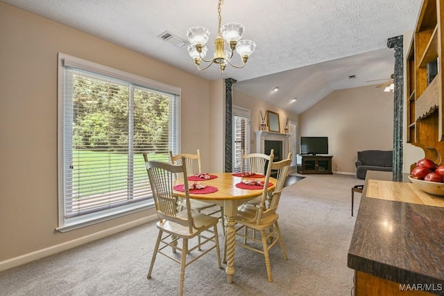 165 Ten Cedars Dr, Titus, AL 36080 - carpeted dining area featuring a chandelier, a textured ceiling, lofted ceiling, ceiling fan, and a fireplace