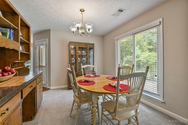 165 Ten Cedars Dr, Titus, AL 36080 - dining area featuring a chandelier, light colored carpet, and a textured ceiling