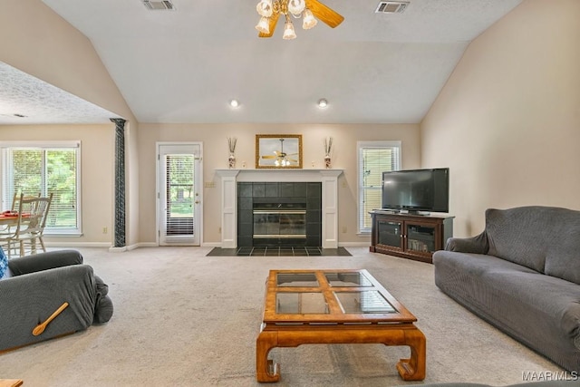 165 Ten Cedars Dr, Titus, AL 36080 - carpeted living area featuring vaulted ceiling, a ceiling fan, and a tiled fireplace