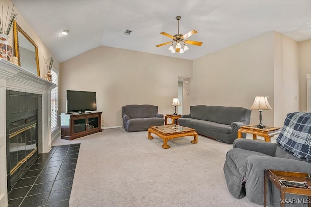165 Ten Cedars Dr, Titus, AL 36080 - living room with a ceiling fan, a tiled fireplace, vaulted ceiling, and dark carpet